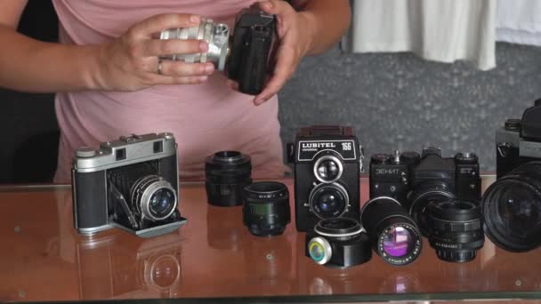Belarus, Soligorsk, 1 de julho de 2019: fotógrafos do sexo masculino mãos encontra lente para uma velha câmera retro soviética em uma coleção de estúdio de fotos — Vídeo de Stock