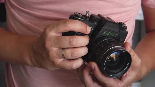 Bielorrusia, Soligorsk, 1 de julio de 2019: los fotógrafos masculinos encuentran una lente para una vieja cámara retro soviética en un estudio fotográfico y comprueban que su trabajo se centra — Vídeo de stock