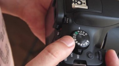 Erkek fotoğrafçı elleri modern dijital kamera modları test ediyor yakın çekimler ayar tekerleği çevirmek