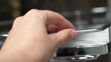 Kadın el dokunuşları mutfak mobilyaları için mobilya parçaları bir dükkan pencere yakın çekim örnek bir bar sayacı için bir tüp üzerinde metal dönen raf