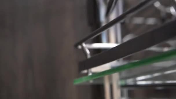 Acessórios de mobiliário para móveis de cozinha prateleira giratória de metal em um tubo para um balcão de bar em uma loja janela close-up amostra — Vídeo de Stock