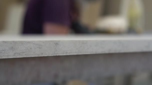 Sten bordsskiva närbild, på bakgrunden är suddig processen för bearbetning av händerna högkvalitativa granit bänkskivor på produktions arbetaren — Stockvideo