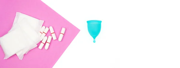 Productos de higiene personal femenina aislados sobre fondo blanco copa menstrual azul y toallitas de hisopo sobre un fondo rosa como opción ecológica cero residuos reutilizable producto durante un período de tiempo —  Fotos de Stock