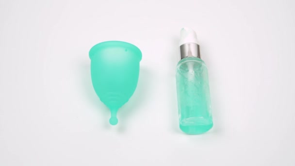 Womans hand uses lubricant to lubricate the menstrual cup intimate personal hygiene product for a comfortable installation during period time — Stock Video