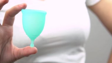 genç kadının elleri yakın çekim mavi adet fincan, adet sırasında kişisel bir hijyen ürünü göstermek