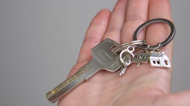 Mujer mano sostiene llavero casa llaves primer plano venta de bienes raíces — Vídeo de stock