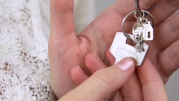 Woman hand holds key chain house keys closeup real estate sale — Stock Video