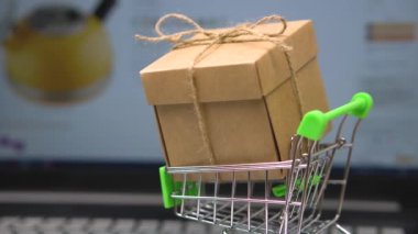 Dizüstü bilgisayar klavyesinde market arabasında kutu. bir online bakkal arka plan aleyhine. teslimat close-up ile ev için online alışveriş