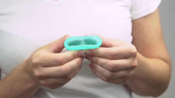 Ruce mladé ženy ukazují, že blízká modrá menstruační pohár tvrdá odrůda, výrobek osobní hygieny během menstruace — Stock video