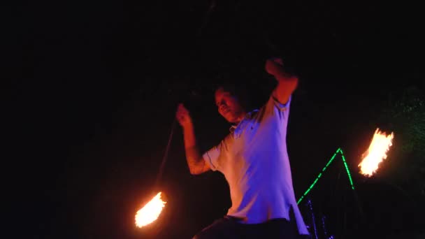 Thaïlande, Phi Phi Island, 28 septembre 2019 : Spectacle d'incendie sur plage ouverte. Un équilibreur masculin concentré se tient sur une corde jongle avec des boules de feu la nuit à l'extérieur portrait en gros plan — Video