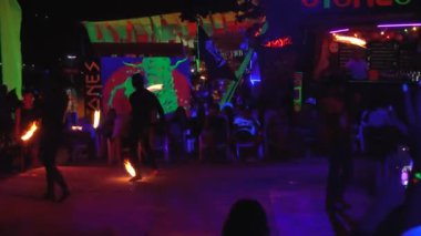 Tayland, Phi Phi Adası, 28 Eylül 2019: Turistler açık bir plaj genel planında gece bir yangın programı izler ve telefonda video çekerler.
