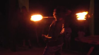 Tayland, Phi Phi Adası, 28 Eylül 2019: açık plajda yangın gösterisi. Hint fakiri boynuna uzun bir alev çubuğu dolamış.