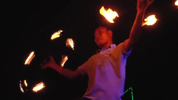 2019 년 9 월 28 일에 확인 함 . Thailand, Phi Phi Island, September 28, 2019: Fire show on open beach. 밤에 야외에서 클로즈업 초상화를 그리며 줄을 서서 춤을 추는 수컷의 모습 — 비디오