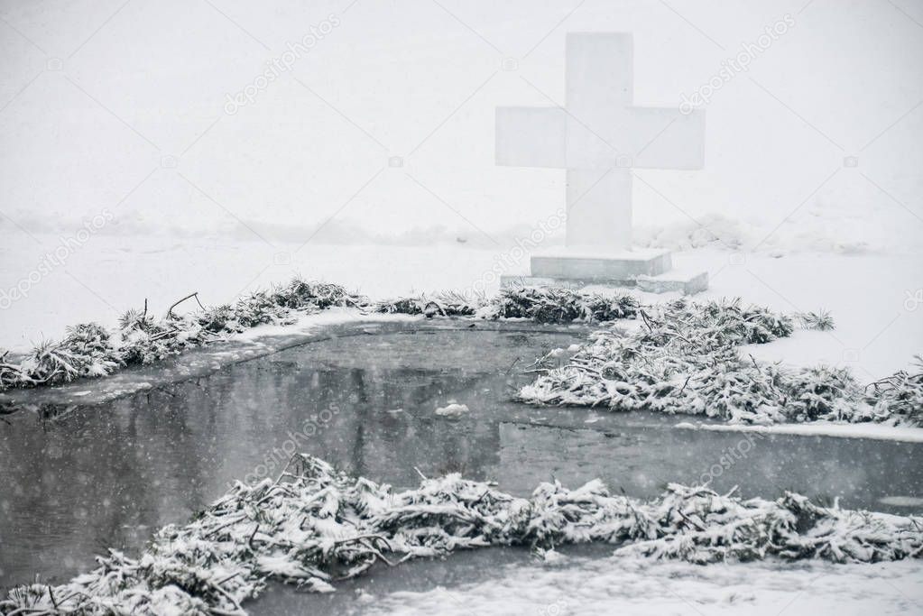 Cross the ice near the hole. In the ice, the cross is erected in the form of a cross. Before the bathing ceremony. Religious holiday of Epiphany. Ukraine. Bilogorodka January 18, 2018