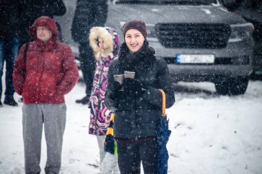 Sokakta gözlüklü bir kızdır. Kar düşüyor. Kız çay tarafından ısıtılır. Tanrı vaftiz bayram arifesinde su kutsama ayini yürütmektedir. Ukrayna. Belogorodka. 19 Ocak 2018