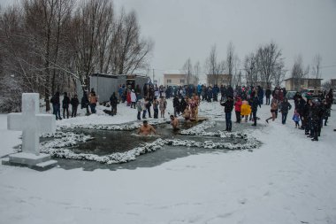 Epifani bayramında delikte toplu yüzme. Buz deliğinde yüzmek. Tanrı'nın Vaftiz bayramı arifesinde ritüel yıkama yürütmek. Ukrayna. Belogorodka. 19 Ocak 2018