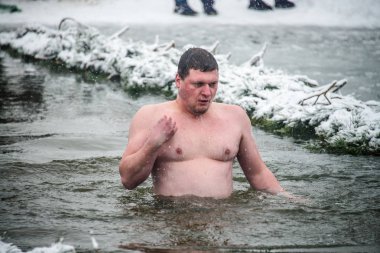 The face of a man vynirivayuschego from the water. Swimming time in the hole. Carrying out the ritual washing on the eve of the feast of the Baptism of the Lord. Ukraine. Belogorodka. January 18, 2018 clipart