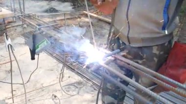 Uzun elektrot metal erir. Elektrot tutucu ile eldivenler içinde el kaynakçı. Elektrot kaynak takviye çubukları. Kıvılcımlar yan yana kırılmaz. Kaynak demir çubuklar. Kiev. Ukrayna. 19 Ekim 2018