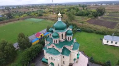 Kamera kilisenin kubbesinin etrafında hareket ediyor. Helikopter yavaşça kilisenin kubbesinin üzerinden uçuyor. Helikopterin kilise arazisi boyunca uçuşu. Kiliseye. Kiev. Bilogorotka. 29.09.2018