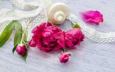 Güzel taze peoniesand ve ahşap yüzey üzerinde bazı süsleri.