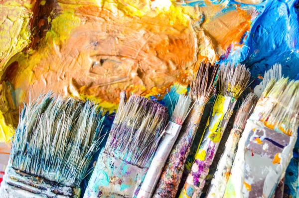 Artist paint brushes and palette. Old brushes. Close up.