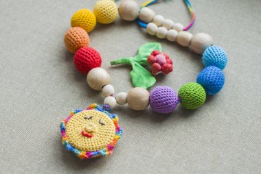 Askıda oturan bebek için örülmüş boncuklardan yapılan kolye. Örülmüş boncuklar. Askı kolyesi.