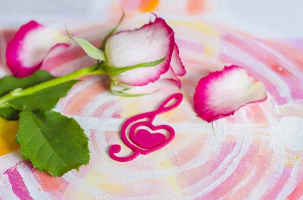 Rosa con un corazón decorativo en forma de una clave de agudos con fieltro rosa . — Foto de Stock