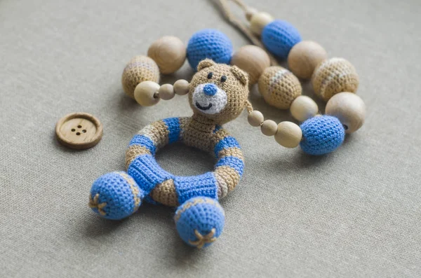 Ketting gemaakt van gebreide kralen en speelgoed voor de baby zitten in een sling. Gebreide kralen. — Stockfoto