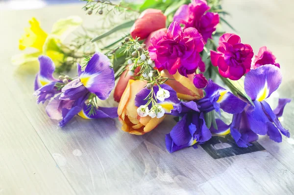 Bouquet di garofani rosa, iris, tulipani, narcisi . — Foto Stock