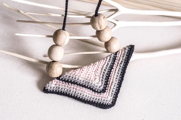 Handcrafted accessories in Scandinavian style. Tie in the form of a triangle, knitted of wooden beads.