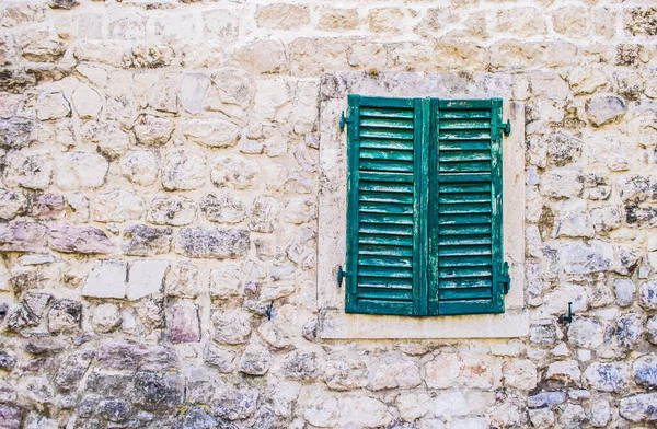 Old stone wall with closed shutters window — Stock Photo, Image