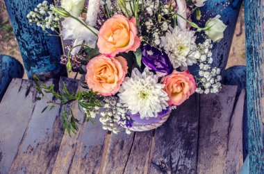 Bir buket turuncu gül ve eski ahşap arka planda kasımpatı. Çiçek buketi fotoğrafı..