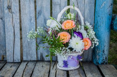 Bir buket turuncu gül ve eski ahşap arka planda kasımpatı. Çiçek buketi fotoğrafı..