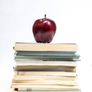 bir yığın kitap üzerine kırmızı elma