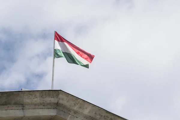 背景に曇り空で手を振っているハンガリーの旗の表示 — ストック写真