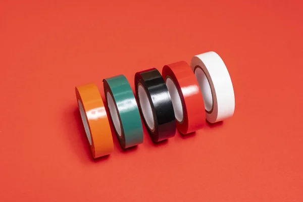 Some Rolls Colored Insulating Tape Red Surface — Stock Photo, Image