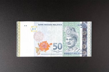 a 50 Malaysian Ringgit banknote on a black surface clipart
