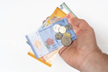 Elinde Malezya Halkası 'na ait banknotlar ve paralar var.