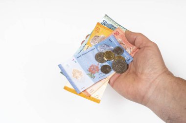 Elinde Malezya Halkası 'na ait banknotlar ve paralar var.