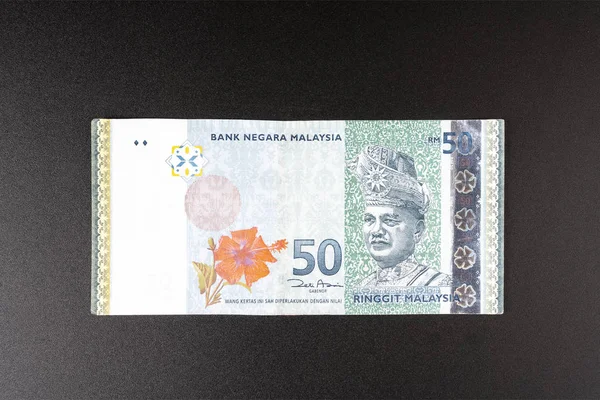 Siyah bir yüzey üzerinde 50 Malezya Halkası banknotu