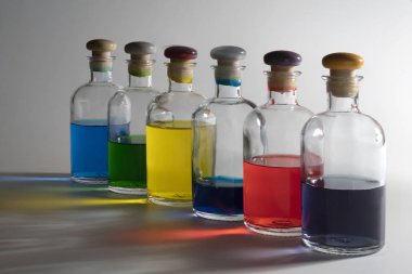 İçinde renkli sıvı bulunan küçük cam şişeler.
