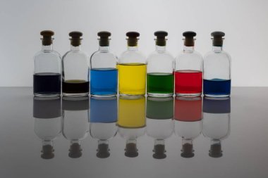 İçinde renkli sıvı bulunan küçük cam şişeler.