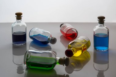 Beyaz bir yüzeye renkli sıvı ile küçük şişeleri