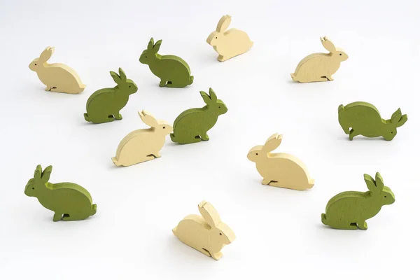 Alcuni coniglietti di Pasqua colorati in legno su una superficie bianca — Foto Stock
