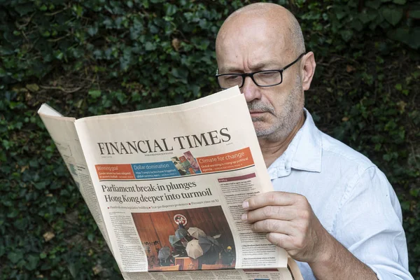 stock image Udine, Italy. July 1, 2019.  A man reads the  Financial times newspaper 