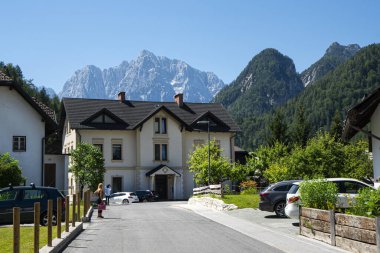 Kraniska Gora, Slovenya. 10 Temmuz 2020 'de Kranjska Gora' nın tarihi merkezinde arka planda Razor Dağı olan eski bir bina.