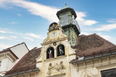 Graz, Avusturya. Ağustos 2020. Glockenspielplatz Meydanı 'ndaki binanın girişinde günde üç kez (11.00, 15.00 & 18.00) geleneksel kostüm piruetiyle giyinmiş tatlı ve sağlıklı bir delikanlı.. 