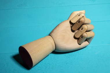 Mavi bir masanın üzerinde tahta bir el