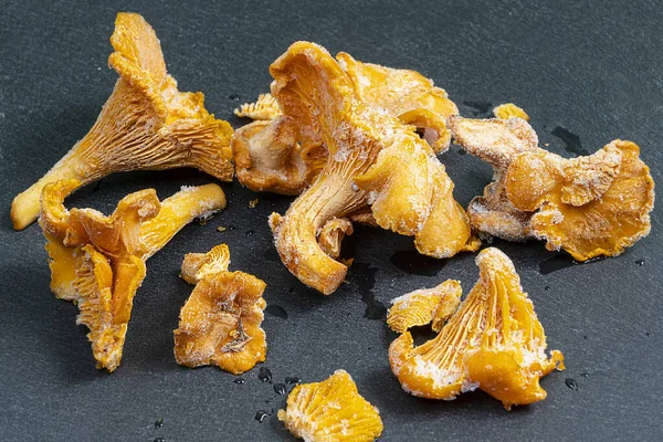 Sommige Bevroren Cantharelles Cantharellus Cibarius Paddenstoelen Een Zwarte Ondergrond — Stockfoto