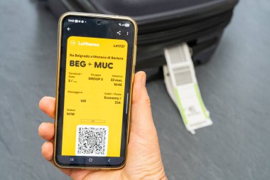 Venedik İtalya. Ağustos 2025. Elinde bavul ve Lufthansa dijital biniş kartıyla seyahate çıkmak.